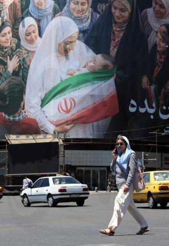 epa12992437 People walk next to a huge billboard in a street in Tehran, Iran, 25 May 2026. The US and Iran voiced optimism regarding a potential peace agreement and the reopening of the Strait of Hormuz, though both sides emphasized that no such deal has been reached yet.  EPA/ABEDIN TAHERKENAREH