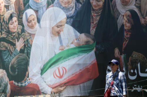 epa12992442 People walk next to a huge billboard in a street in Tehran, Iran, 25 May 2026. The US and Iran voiced optimism regarding a potential peace agreement and the reopening of the Strait of Hormuz, though both sides emphasized that no such deal has been reached yet.  EPA/ABEDIN TAHERKENAREH