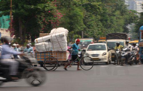 epa12994952 A van rickshaw puller pulls a loaded van during a hot afternoon in Kolkata, India, 26 May 2026. The India Meteorological Department (IMD) has forecast temperatures to reach up to 43 degrees Celsius as a heat wave persists across West Bengal.  EPA/PIYAL ADHIKARY