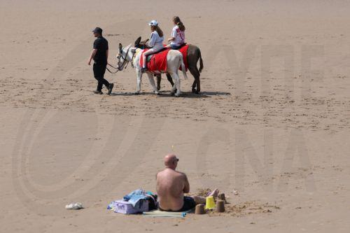 epa12997820 People ride donkeys on the beach at the seaside resort of Blackpool, Britain, 27 May 2026. The UK is experiencing a record-breaking heatwave, with temperatures exceeding 35 degrees Celsius, marking the hottest May on record.  EPA/ADAM VAUGHAN