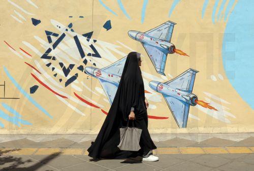 epa13012529 An Iranian woman walks next to an anti-US and Israeli mural in Tehran, Iran, 03 June 2026. Iran and the US traded strikes despite a ceasefire as the conflict involving Iran, the US, and Israel continues. According to US Central Command (CENTCOM), US forces intercepted multiple Iranian ballistic missiles and drones and conducted self-defense...
