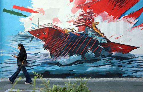 epa13012531 An Iranian woman walks next to an anti-US and Israeli mural in Tehran, Iran, 03 June 2026. Iran and the US traded strikes despite a ceasefire as the conflict involving Iran, the US, and Israel continues. According to US Central Command (CENTCOM), US forces intercepted multiple Iranian ballistic missiles and drones and conducted self-defense...