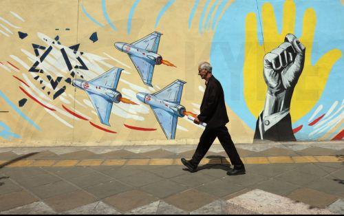 epa13012534 An Iranian man walks next to an anti-US and Israeli mural in Tehran, Iran, 03 June 2026. Iran and the US traded strikes despite a ceasefire as the conflict involving Iran, the US, and Israel continues. According to US Central Command (CENTCOM), US forces intercepted multiple Iranian ballistic missiles and drones and conducted self-defense...
