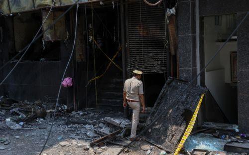 epa13012772 Police personnel are seen at the site of fire in a hotel in New Delhi, India, 03 June 2026. According to authorities, at least 21 people have died and several others have been seriously injured following a fire in a hotel in the Malviya Nagar area of New Delhi.  EPA/RAJAT GUPTA