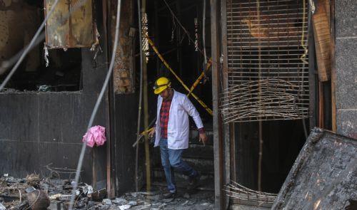 epa13012811 A forensic team member inspects the site of fire in a hotel in New Delhi, India, 03 June 2026. According to authorities, at least 21 people have died and several others have been seriously injured following a fire in a hotel in the Malviya Nagar area of New Delhi.  EPA/RAJAT GUPTA