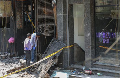 epa13012897 Forensic team members inspect the site of fire in a hotel in New Delhi, India, 03 June 2026. According to authorities, at least 21 people have died and several others have been seriously injured following a fire in a hotel in the Malviya Nagar area of New Delhi.  EPA/RAJAT GUPTA