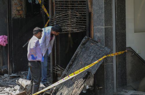 epa13012899 Forensic team members inspect the site of fire in a hotel in New Delhi, India, 03 June 2026. According to authorities, at least 21 people have died and several others have been seriously injured following a fire in a hotel in the Malviya Nagar area of New Delhi.  EPA/RAJAT GUPTA