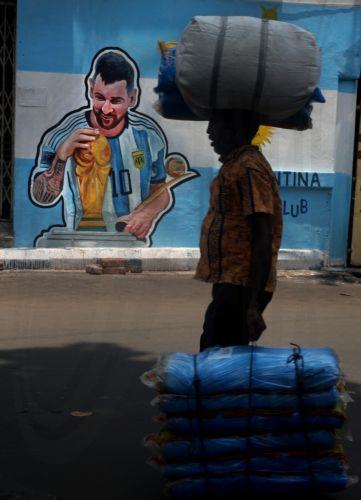 epa13032255 An Indian man passes near a street mural depicting Lionel Messi of Argentina in Kolkata, india, 12 June 2026. The FIFA World Cup 2026 runs from 11 June to 19 July 2026.  EPA/PIYAL ADHIKARY