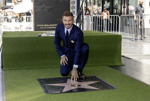epa13033486 British former soccer player David Beckham (C) poses next to his star during a ceremony honoring him on the Hollywood Walk of Fame in Los Angeles, California, USA, 12 June 2026. Beckham was recognized in the Sports Entertainment category.  EPA/TED SOQUI
