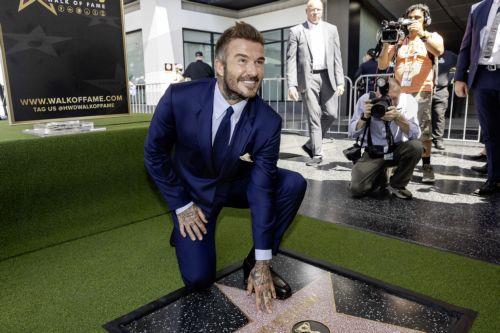 epa13033492 British former soccer player David Beckham poses next to his star during a ceremony honoring him on the Hollywood Walk of Fame in Los Angeles, California, USA, 12 June 2026. Beckham was recognized in the Sports Entertainment category.  EPA/TED SOQUI