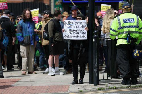 epa13034185 A counter protester holds up a sign on County Road in Liverpool, Britain, 13 June 2026. Anti-immigration protesters calling for 'mass deportation' were met by counter-protesters on County Road, where a community library was burned down during rioting in the wake of the Southport murders in 2024.  EPA/STRINGER