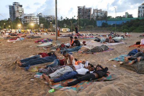 epa13048331 Residents from a nearby slum sleep on Versova Beach near the Arabian Sea shore in Mumbai, India, 19 June 2026. The India Meteorological Department (IMD) has issued a yellow alert for multiple regions of Maharashtra including Mumbai due to persisting heatwave conditions.  EPA/DIVYAKANT SOLANKI