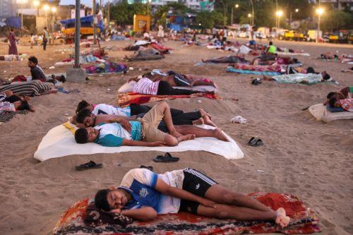 epa13048333 Residents from a nearby slum sleep on Versova Beach near the Arabian Sea shore in Mumbai, India, 19 June 2026. The India Meteorological Department (IMD) has issued a yellow alert for multiple regions of Maharashtra including Mumbai due to persisting heatwave conditions.  EPA/DIVYAKANT SOLANKI