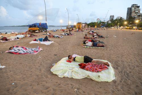 epa13048336 Residents from a nearby slum sleep on Versova Beach near the Arabian Sea shore in Mumbai, India, 19 June 2026. The India Meteorological Department (IMD) has issued a yellow alert for multiple regions of Maharashtra including Mumbai due to persisting heatwave conditions.  EPA/DIVYAKANT SOLANKI