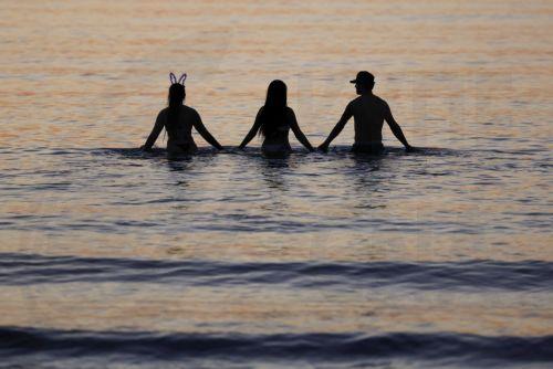 epa13060125 Revellers join hands while bathing in the sea at sunrise at Malvarrosa Beach after the Night of San Juan celebrations in Valencia, Spain, 24 June 2026. To welcome the summer solstice, Spain comes alive during the Night of San Juan from 23 to 24 June. The celebration features bonfires on beaches and town squares, culminating at midnight when...