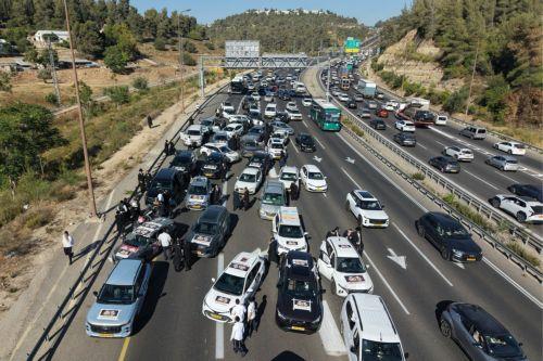 epa13061133 Ultra-Orthodox Jews driving in a convoy of cars to disrupt traffic as part of a national protest against the army recruitment in Jerusalem, 24 June 2026. Ultra-Orthodox protesters in various locations of the country disrupted traffic, calling for a protest against the conscription of ultra-Orthodox Jews into the IDF.  EPA/ABIR SULTAN EPA