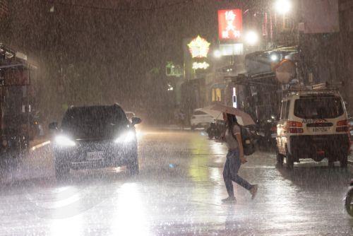 epa13063450 A person  walks across the street during a downpour of rain in Taipei, Taiwan, 25 June 2026. The local authorities in Hualien County ordered evacuations in parts of Wanrong and Fenglin following a yellow alert that a nearly full upstream barrier lake might overflow within 48 hours. Rainfall tied to Severe Tropical Storm Mekkhala was expected,...