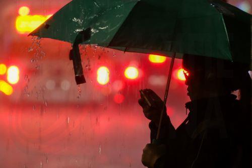 epa13063456 A person  walks across the street during a downpour of rain in Taipei, Taiwan, 25 June 2026. The local authorities in Hualien County ordered evacuations in parts of Wanrong and Fenglin following a yellow alert that a nearly full upstream barrier lake might overflow within 48 hours. Rainfall tied to Severe Tropical Storm Mekkhala was expected,...