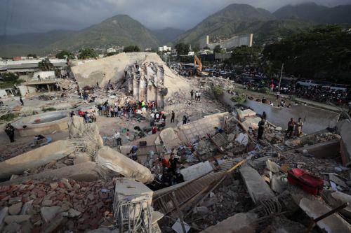 epa13068185 People conduct search operations in an area affected by an earthquake in La Guaira, Venezuela, 26 June 2026. Venezuelan Interior Minister Diosdado Cabello announced that access to La Guaira state, the area hardest hit by the earthquakes, will be restricted starting at 20:00 local time (00:00 GMT on 27 June).  EPA/Ronald Pena R