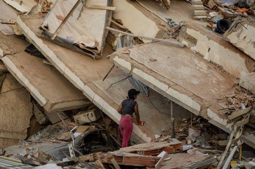 epa13070212 A woman looks at a building damaged by an earthquake in La Guaira, Venezuela, 27 June 2026.  EPA/Henry Chirinos