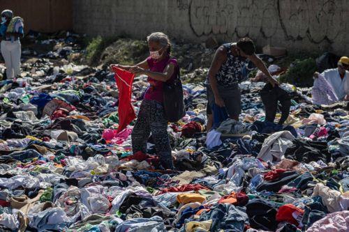 epa13070216 People look through donated clothing in La Guaira, Venezuela, 27 June 2026.  EPA/Henry Chirinos