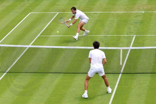 epa13072332 Cameron Norrie (top) of Great Britain plays a backhand in his Men's Singles first round match against Michael Zheng of the USA at the Wimbledon Championships in London, Britain, 29 June 2026.  EPA/NEIL HALL