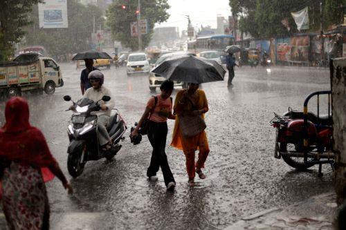 epa13072415 People make their way through a water logged street during heavy rain in Kolkata, India 29 June 2026. The India Meteorological Department (IMD) issued a red alert for thunderstorms with lightning and heavy rainfall, disrupting daily life across parts of West Bengal for the past several days.  EPA/PIYAL ADHIKARY