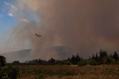epa13080059 A Canadair firefighting plane helps to extinguish a fire as smoke rises from a wildfire burning in Pouzols-Minervois, Aude department, southern France, 02 July 2026. A large wildfire has been raging in southern France since 01 July, forcing scores of people to be evacuated, emergency services said.  EPA/CHLOE REULET