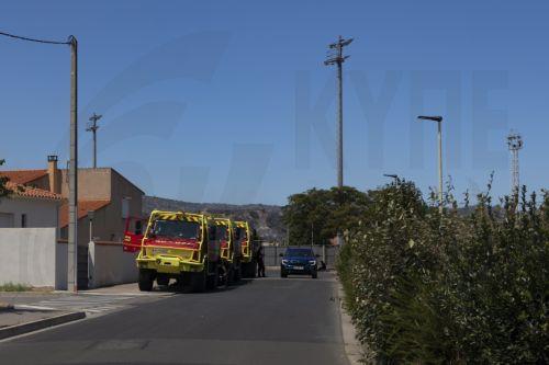 epa13091786 Fire trucks are positioned along the roadside as a wildfire burns in Ille-sur-Tet, southern France, 06 July 2026. The fire has scorched some 4,600 hectares in the foothills of the French Pyrenees, and more than 10,000 people have been ordered to leave, local prefect Pierre Regnault de la Mothe said.  EPA/CHLOE REULET