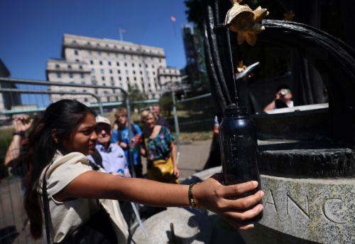 epa13098218 People fill bottles at a water fountain in London, Britain, 08 July 2026. Amber and yellow heat-health alerts are in place across England as the UK braces for one of the longest-lasting heatwaves for fifty years. Temperatures may rise as high as 35 degrees Celsius for parts of southern England this week.  EPA/ANDY RAIN