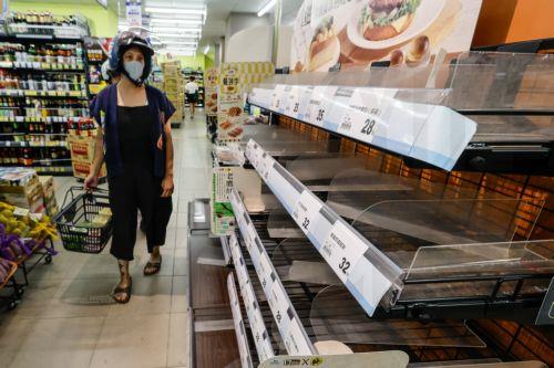 epa13102355 A resident looks at empty bread shelves while grocery shopping in preparation as Typhoon Bavi approaches Hualien city, Taiwan, 10 July 2026. The Central Weather Administration expects Typhoon Bavi to impact Taiwan most severely from 10 July night through 11 July. Currently located 590 km east of Eluanbi and packing maximum sustained winds of 155...