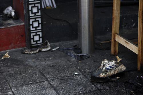 epa13107984 Victims' shoes lie at the scene of a fatal fire at a pub in Bangkok, Thailand, 13 July 2026. At least 27 people were killed and 63 others were injured after a fire engulfed the pub, according to the Royal Thai Police.  EPA/RUNGROJ YONGRIT