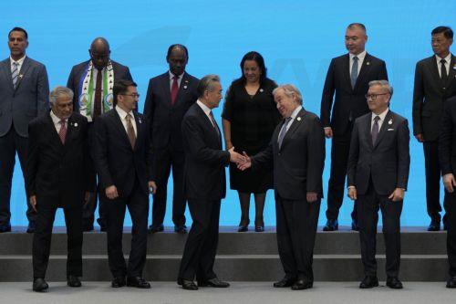 epa13115199 Chinese Foreign Minster Wang Yi (C-L) shakes hands with UN Secretary-General Antonio Guterres before a group photo with other signatories of the Agreement on the Establishment of The World Artificial Intelligence Cooperation Organization ahead of the World AI Conference in Shanghai, China, 16 July 2026.  EPA/NG HAN GUAN / POOL