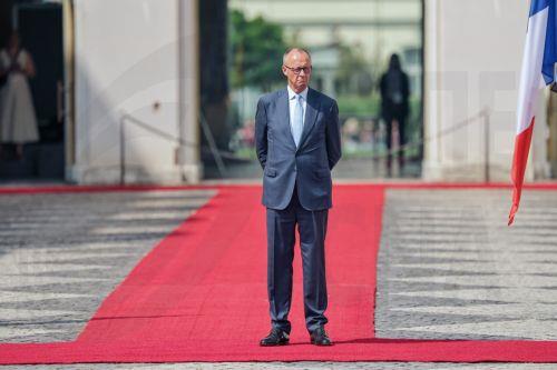 epa13116804 German Chancellor Friedrich Merz awaits French President Emmanuel Macron to inspect the guard of honor ahead of the 26th Franco-German Ministerial Council at Augustusburg Palace in Bruehl, Germany, 17 July 2026. France and Germany are expected to announce the first ever participation of German soldiers in French nuclear weapons exercises. Berlin...
