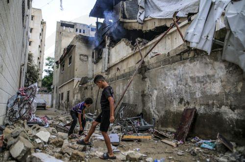 epa13124387 Palestinian youths stand amid the rubble from the destroyed house of the Al-Masri family following an Israeli attack, in Gaza City, Gaza Strip, 21 July 2026. Firas Al-Masri, his wife, Salsabil, and their four children were killed in Gaza City, when the Israeli army targeted their home with a drone early 21 July, according to the Gaza Ministry of...