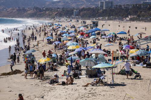 epa13125742 People enjoy the beach along the Santa Monica Pier in Santa Monica, California, USA, 21 July 2026. A heat wave sweeping across Southern California has brought high temperatures to the region, prompting people to seek relief at the coast.  EPA/CHRIS TORRES