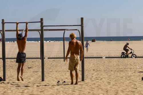 epa13125748 People work out on the beach along the Santa Monica Pier in Santa Monica, California, USA, 21 July 2026. A heat wave sweeping across Southern California has brought high temperatures to the region, prompting people to seek relief at the coast.  EPA/CHRIS TORRES