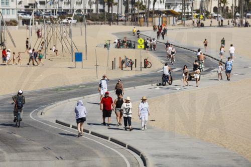 epa13125752 People walk on the beach along the Santa Monica Pier in Santa Monica, California, USA, 21 July 2026. A heat wave sweeping across Southern California has brought high temperatures to the region, prompting people to seek relief at the coast.  EPA/CHRIS TORRES