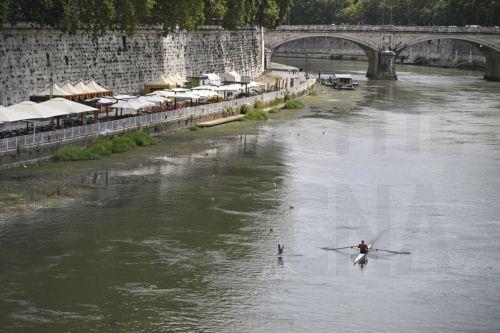 epa13127870 A man rows on the Tiber River which is running low near Castel Sant'Angelo due to heat and drought, in Rome, Italy, 23 July 2026.  EPA/RICCARDO ANTIMIANI