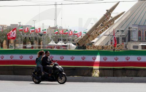 epa13129786 An Iranian couple rides a motorbike next to Iranian missiles, Zolfaghar, on display at Azadi Square in Tehran, Iran, 24 July 2026. Conflict between Iran and the US over the Strait of Hormuz continues, as US strikes have targeted several locations across Iran.  EPA/ABEDIN TAHERKENAREH RESTRICTIONS: NO Access Israel Media/Persian Language TV...