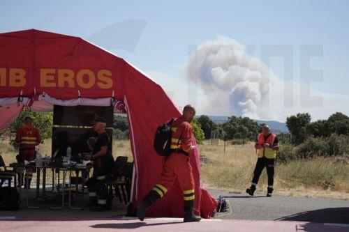 epa13129875 Staff members walk outside a tent at an Advanced Command Post (PMA) monitoring the wildfires in the Cenicientos municipality, Community of Madrid, Spain, 24 July 2026. Commanders of the operation against the forest fire affecting the southwest of the Autonomous Community of Madrid ordered the evacuation of the municipalities of Chapineria, Navas...