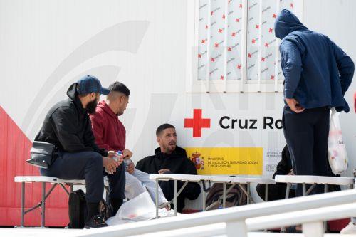epa13130176 Newly arrived migrants wait at a Red Cross point in the port of Gran Tarajal, Fuerteventura, Spain's Canary Islands, 24 July 2026. About 20 migrants arrived on Fuerteventura island aboard a possibly stolen fishing vessel from El Aaiun, Western Sahara, according to the Civil Guard and emergency services.  EPA/CARLOS DE SAA