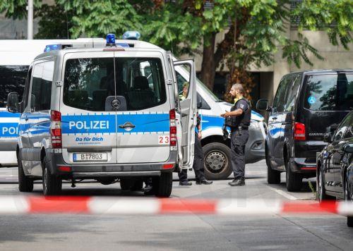 epa13133457 Police officers stand at a building after an apartment was searched last night near the scene where a vehicle plowed into a crowd on the sidelines of the Christopher Street Day (CSD) parade in Berlin, Germany, 26 July 2026.  One person died and 16 others were injured on the sidelines of the Christopher Street Day event in Berlin after a vehicle...