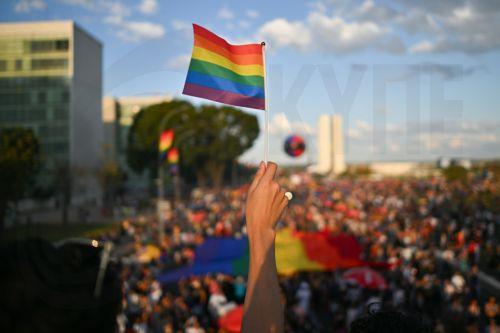 epa13134880 A person holds a flag during the LGBT Pride march on the Esplanade of the Ministries in Brasilia, Brazil, 26 July 2026.  EPA/Andre Borges