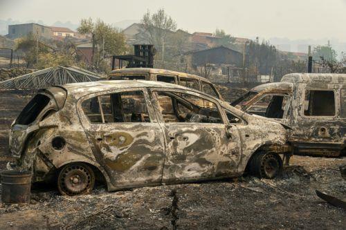 epa13135620 Burnt cars at the village of Casavieja, Avila, Spain, 27 July 2026. In Avila's region, 15 villages have been evacuated due to the fire. Multiple fires in Spain have forced the evacuation of about 115,000 people from the affected villages.  EPA/RAUL SANCHIDRIAN