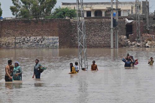epa13135841 People wade through a flooded area after heavy monsoon rains raised the water level of the Ravi River in Muridke, Pakistan, 27 July 2026. Authorities established 17 flood relief camps across Lahore Division, mainly in Nankana Sahib and Sheikhupura, and introduced an AI-based dashboard to monitor reservoir conditions and support flood...