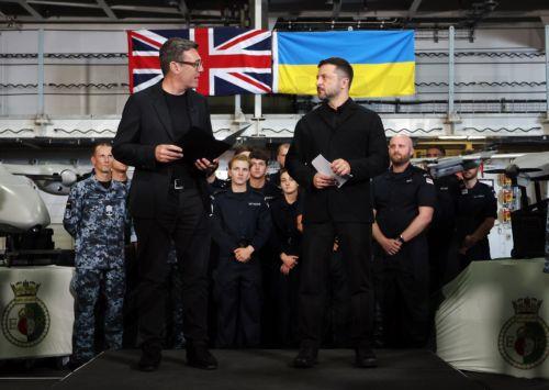 epa13135924 British Prime Minister Andy Burnham (L) and Ukrainian President Volodymyr Zelensky (R)  with British and Ukrainian troops aboard the HMS Queen Elizabeth at His Majesty's Naval Base Portsmouth in Portsmouth, Britain, 27 July 2026.  EPA/ANDY RAIN / POOL