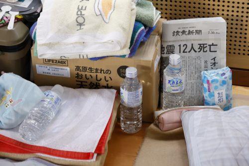 epa13141135 Resting space for people affected by the earthquake, with food water and newspaper headline writing '12 people killed' in the Matsubashi-Higashi Emergency Control Centre in Uki, Kumamoto Prefecture, in southwestern Japan, 30 July 2026. Rescue operations continue across Kumamoto Prefecture, where more than a dozen people have died and several...