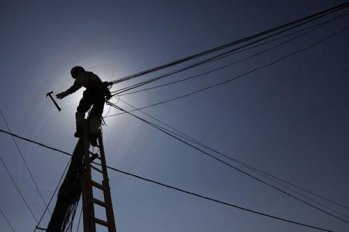epa13141256 A worker is repairing the power grid following a wildfire in Carbonaire at La Vall d'Uixo, Castellon, Spain, 30 July 2026. The fire, which was declared on 25 July 2026, is still not under control and has already burned 9,300 hectares, with a perimeter of 84 kilometers.  EPA/KAI FOERSTERLING