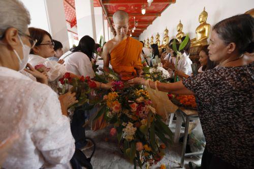 epa13141331 A Thai Buddhist monk is offered flowers by devotees during the floral alms offering ceremony marking the start of Buddhist Lent or 'Khao Phansa' at Wat Phra Chetuphon Wimonmangkalaram Ratchaworamahawihan or Wat Pho in Bangkok, Thailand, 30 July 2026. The traditional floral alms offering is held to mark the start of Buddhist Lent, which begins...